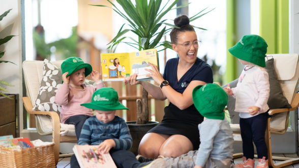 Teacher reading a picture book to toddlers at Edge Early Learning kids themselves