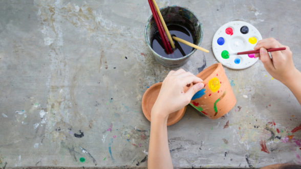 Child painting clay pot during a fun pottery project