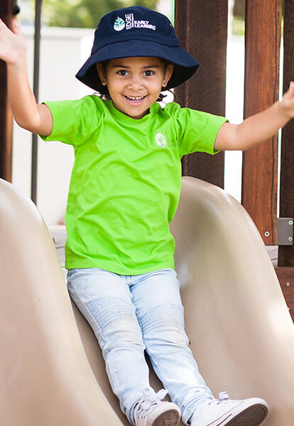 Smiling child on slide at Edge Early Learning childcare centre
