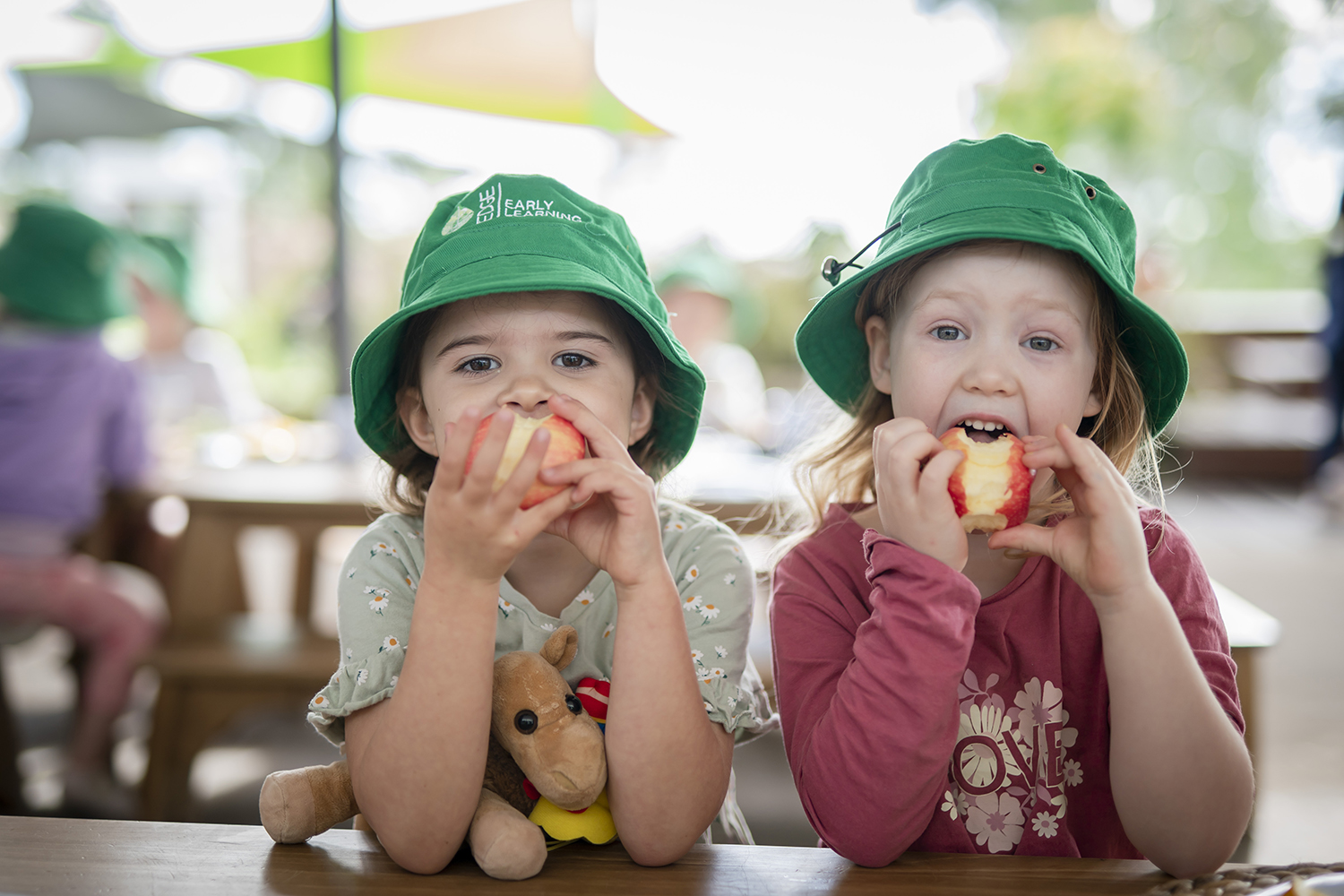 Two girls eating apples