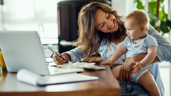 Mother holding baby doing paperwork